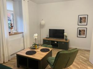 a living room with a table and a tv at Apartament Frezja in Gryfów Śląski