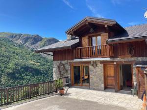 ein Haus mit Balkon auf einem Berg in der Unterkunft Chalet 18 personnes 8 chambres aux 3 vallees, menuires in Saint-Marcel