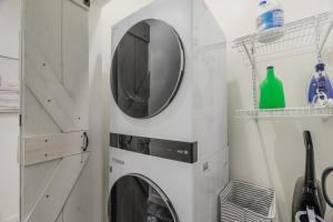 a laundry room with a washing machine and a mirror at Stylish 4BR Haven: Serene Backyard and Fire Pit in Charlotte