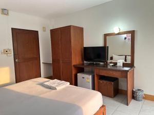 a bedroom with a bed and a desk with a mirror at ปะการังแมนชั่น in Udon Thani +6 photos