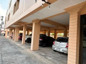 a parking lot with cars parked in front of a building at ปะการังแมนชั่น in Udon Thani