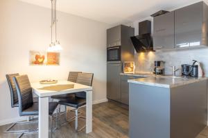 a kitchen with a white table and chairs in a room at Ferienwohnung Ebbe in Hooksiel