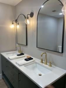 a bathroom with two sinks and a large mirror at Farm House with River Access to Guadalupe River in New Braunfels