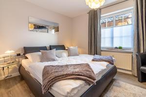 a bedroom with a large bed and a window at Ferienwohnung Ebbe in Hooksiel +2 photos