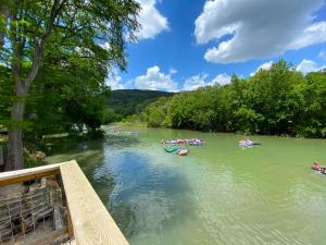 a group of people in boats on a river at Farm House with River Access to Guadalupe River in New Braunfels