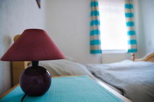 a lamp sitting on a table next to a bed at Ferienwohnung Boje 10 in Schillig +3 photos