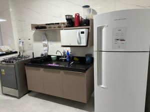 a kitchen with a white refrigerator and a stove at CasaAju - Sua nova opção de hospedagem em Aracaju, reformada e toda mobiliada, com tudo novinho, no capricho só para você in Aracaju