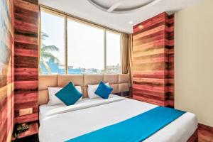 a bedroom with a large bed with blue pillows at Super Hotel O Park Circus Near Birla Mandir in Kolkata