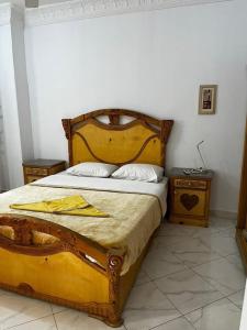 a bedroom with a large bed with a wooden frame at Sekhmet Appartement 2 chambres in Luxor