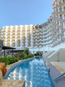 a swimming pool in front of a large building at Cádiz Bahía by QHotels in Cádiz