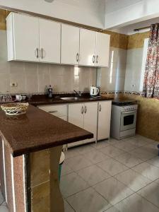 a kitchen with white cabinets and a counter top at Sekhmet Appartement 2 chambres in Luxor