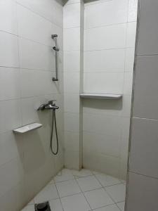 a white bathroom with a shower with a hose at Sekhmet Appartement 2 chambres in Luxor
