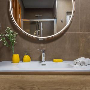 Un lavabo de baño con un espejo y un jarrón amarillo. en Spinola Seafront Deluxe, en San Julián 14 fotos más