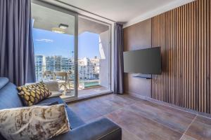 Una sala de estar con un sofá y una ventana grande. en Spinola Seafront Deluxe, en San Julián