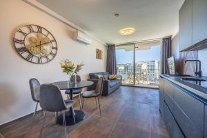 cocina y sala de estar con reloj en la pared en Spinola Seafront Deluxe, en San Julián
