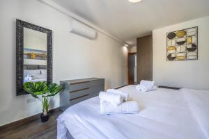 1 dormitorio con 1 cama blanca grande y toallas en Spinola Seafront Deluxe, en San Julián