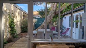 przesuwane szklane drzwi na patio ze stołem i krzesłami w obiekcie Villa Bagatelle à 300m de la plage centrale, 3 chambres w Arcachon