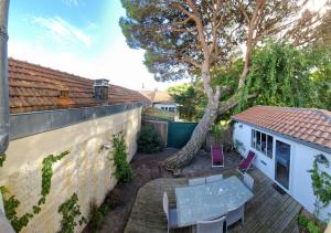 patio ze stołem, krzesłami i drzewem w obiekcie Villa Bagatelle à 300m de la plage centrale, 3 chambres w Arcachon