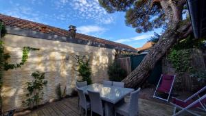 patio ze stołem, krzesłami i drzewem w obiekcie Villa Bagatelle à 300m de la plage centrale, 3 chambres w Arcachon +25 zdjęć