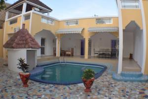 a house with a swimming pool in front of it at Villa Amoul Solo - Villa Sans Soucis in Saly Niakh-Niakhal