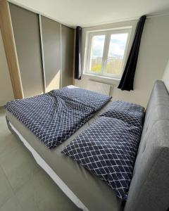 ein Bett mit zwei Kissen darauf in einem Schlafzimmer in der Unterkunft Apartmán Sunrise 19 in Michalovce