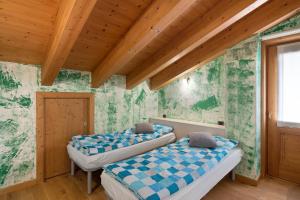 two beds in a room with green wallpaper at Casa Daniele-Appartamento Livia in Livigno