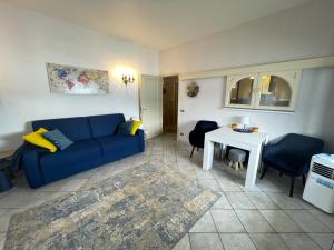 a living room with a blue couch and a table at Blue Lake View in Oggebbio