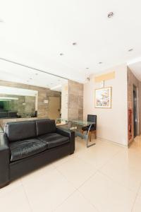 a living room with a black couch and a table at Le Batiment Apartments in Buenos Aires +128 photos