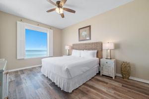 a bedroom with a bed with a ceiling fan and a window at Spanish Key Unit 602 in Pensacola