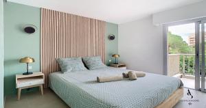 una camera da letto con un letto e una grande finestra di Genêts - 47m2 - 4 pers - Cozy - Climatisé a Le Cannet Altre 4 foto