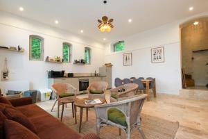 a living room with a couch and a table and chairs at Magnifiques Ecuries juste rénovées - Domaine de la Mulotière in Langeais