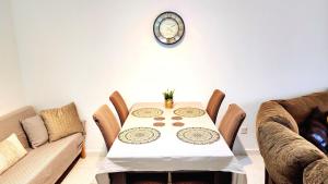 a dining room with a table and a clock on the wall at CSS Comfy Smart Superior By King's Palace in Paphos City