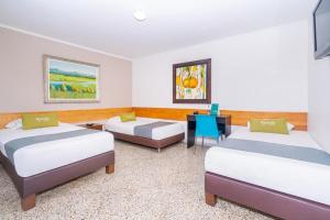a hotel room with two beds and a desk at HOTEL OASIS in Rionegro +12 photos