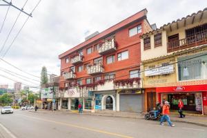 a woman walking down a street in front of a building at HOTEL OASIS in Rionegro