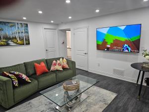 un soggiorno con un divano verde e una TV di Cosy Spacious 2 bedrooms a Oakville