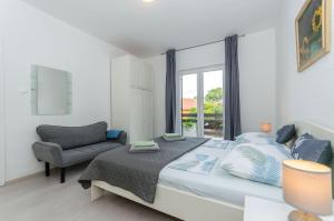 una camera da letto con un letto, una sedia e una finestra di Apartments Bartz a Jelsa (Gelsa)