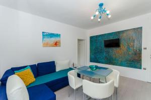 un soggiorno con un divano blu e un tavolo di Apartments Bartz a Jelsa (Gelsa)
