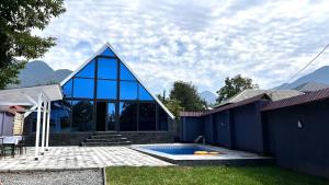 a house with a blue building with a swimming pool at A Frame Villa Gabala in Gabala