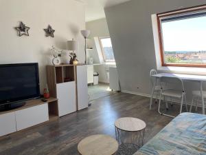 a living room with a television and a table and chairs at Grand studio Centre-ville avec ascenseur in Calais