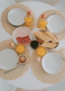 a table with plates and utensils and food on it at Casa de Luz - Beach & Boulevard in Torrevieja +32 photos