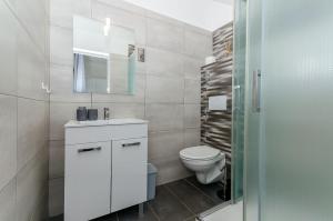un bagno bianco con un water e un lavandino di Apartments Bartz a Jelsa (Gelsa) Altre 17 foto