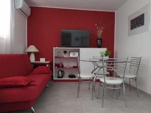 a living room with a table and a red wall at House Vlasta in Primošten