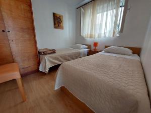a small bedroom with two beds and a window at House Vlasta in Primošten