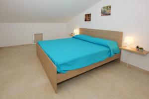 a bedroom with a large bed with a blue blanket at Astro apartments with direct access on the sea of Noto heritage of Unesco in Noto