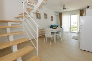 a kitchen and dining room with a staircase and a table at Astro apartments with direct access on the sea of Noto heritage of Unesco in Noto