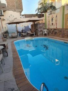une grande piscine bleue avec un requin. dans l'établissement Villa Omar El Sharif Appartement avec Piscine n1, à Louxor
