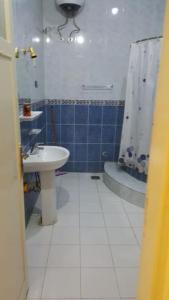 une salle de bain avec un lavabo, des toilettes et une douche dans l'établissement Villa Omar El Sharif Appartement avec Piscine n1, à Louxor