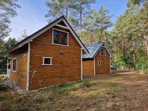 a small wooden house in the middle of a yard at Leśny Domek Rotembark z prywatnym jacuzzi in Kościerzyna