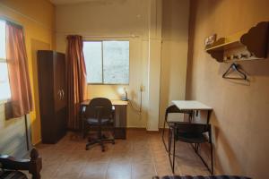 Treinta y TresCasa Tuna的客房设有桌子、椅子和窗户。