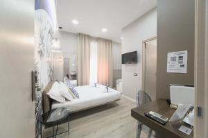 サレルノにあるB&B Les Lumièresのベッドルーム(白いベッド1台、テーブル、デスク付)